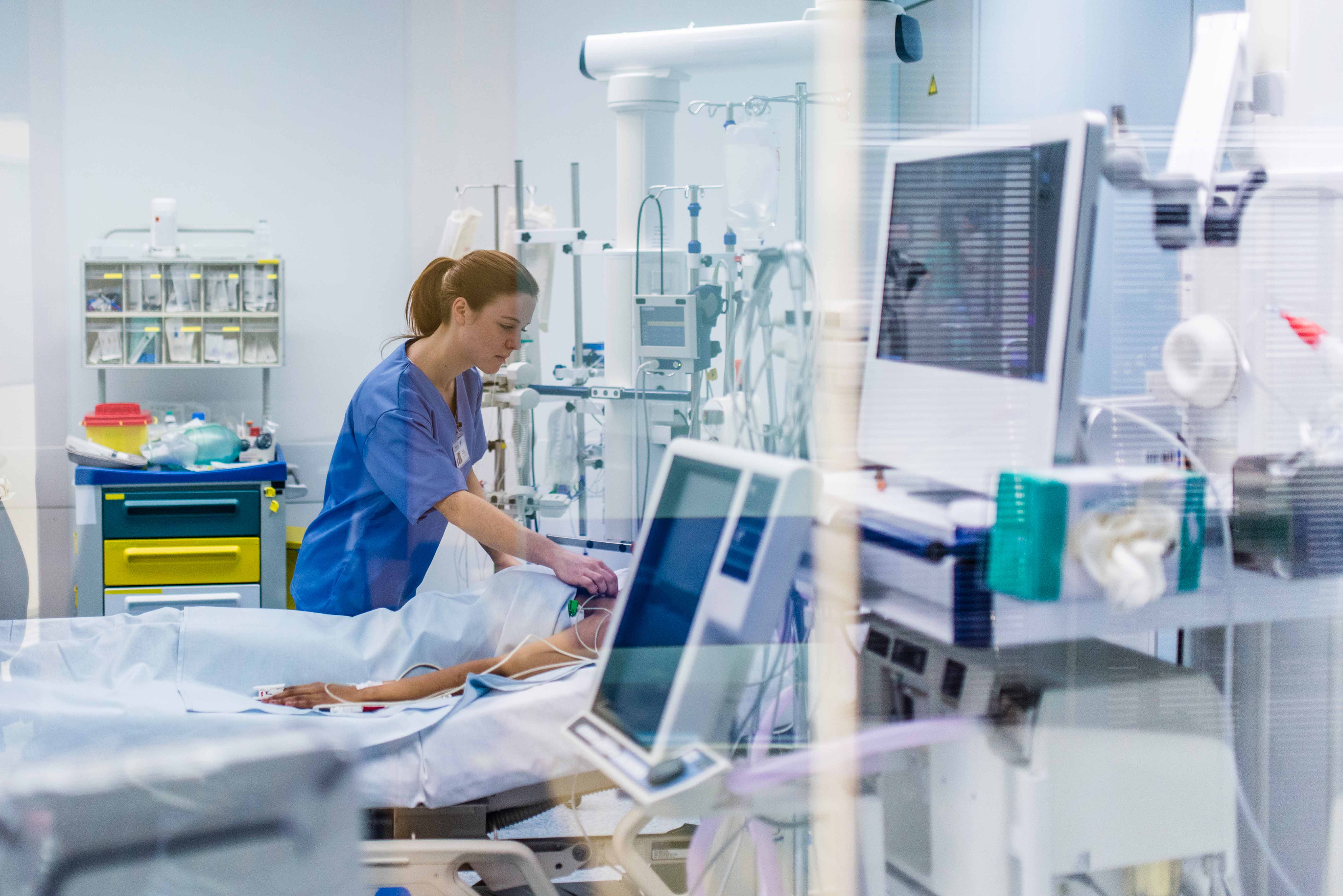 nurse monitoring patient in hospitall bed